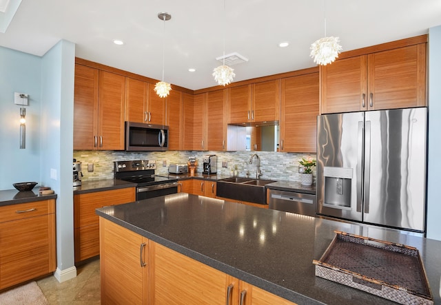 kitchen featuring tasteful backsplash, hanging light fixtures, stainless steel appliances, and sink