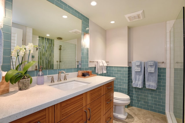 bathroom featuring tile walls, an enclosed shower, vanity, tile patterned floors, and toilet