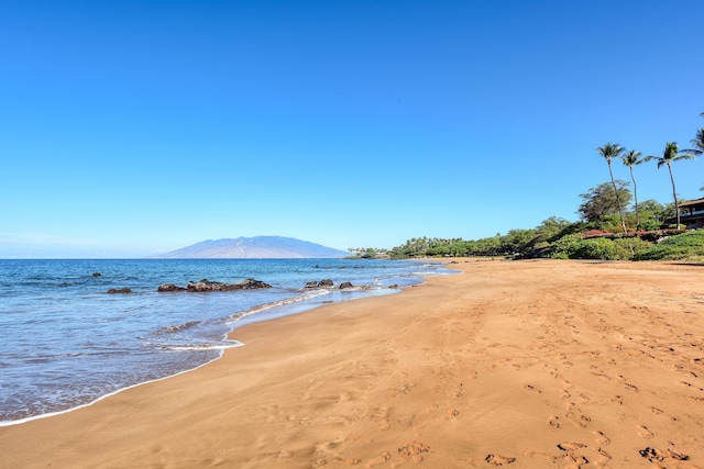 view of water feature with a beach view and a mountain view