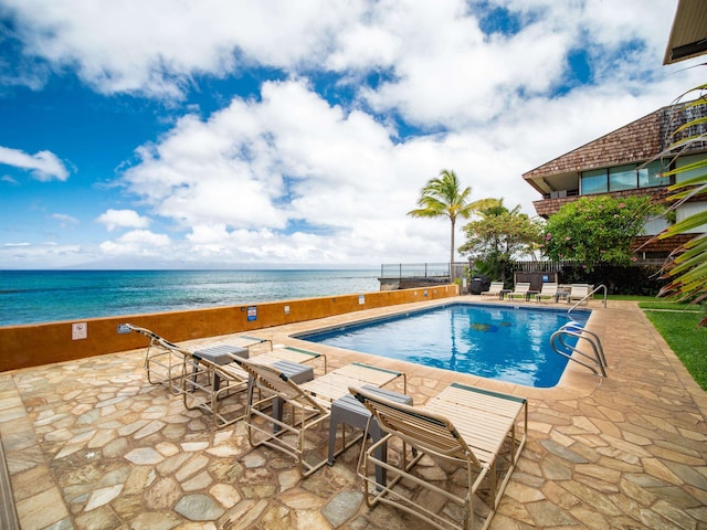 view of pool featuring a patio area and a water view