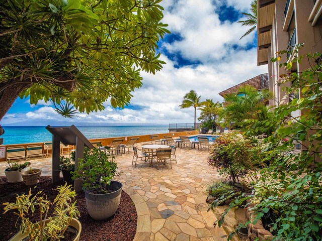 view of patio / terrace featuring a community pool and a water view