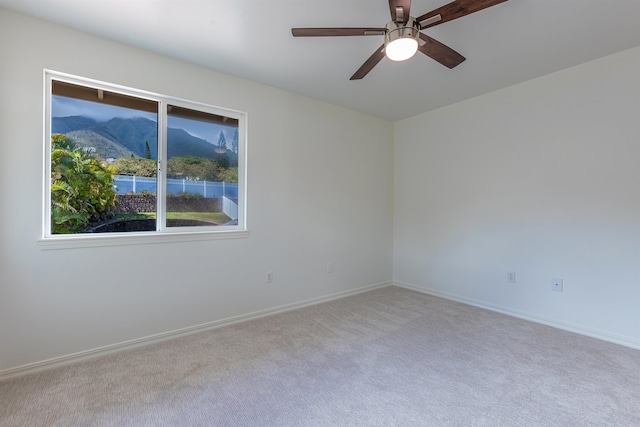 carpeted spare room with ceiling fan