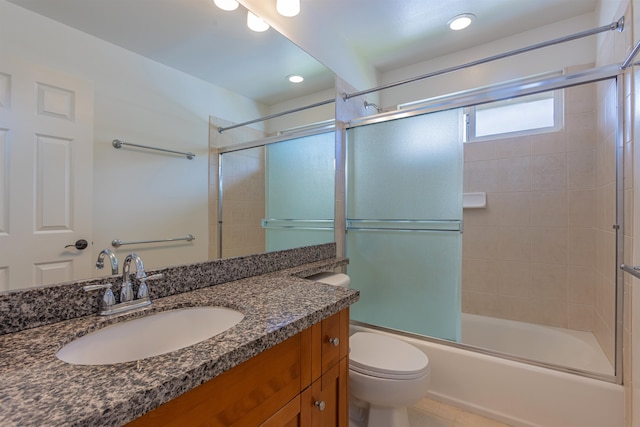 full bathroom featuring combined bath / shower with glass door, vanity, and toilet