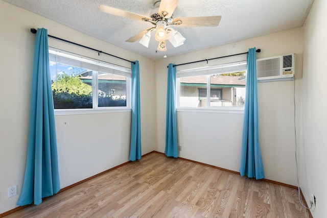 empty room featuring a textured ceiling, ceiling fan, light wood-style flooring, and baseboards