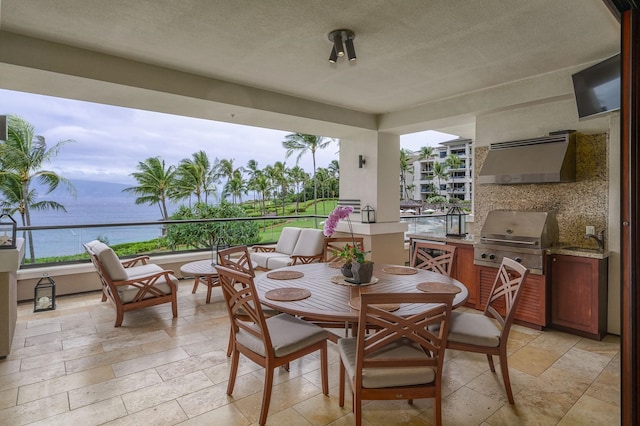 view of patio with sink, grilling area, a water view, and exterior kitchen