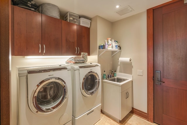 laundry room with sink, light tile patterned floors, cabinets, and washing machine and clothes dryer