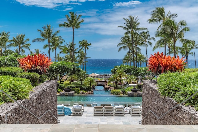 view of swimming pool featuring a patio and a water view