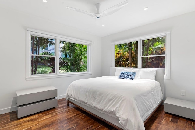 bedroom with multiple windows, dark hardwood / wood-style floors, and ceiling fan