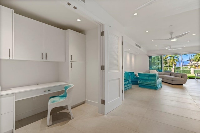 tiled home office featuring built in desk and ceiling fan