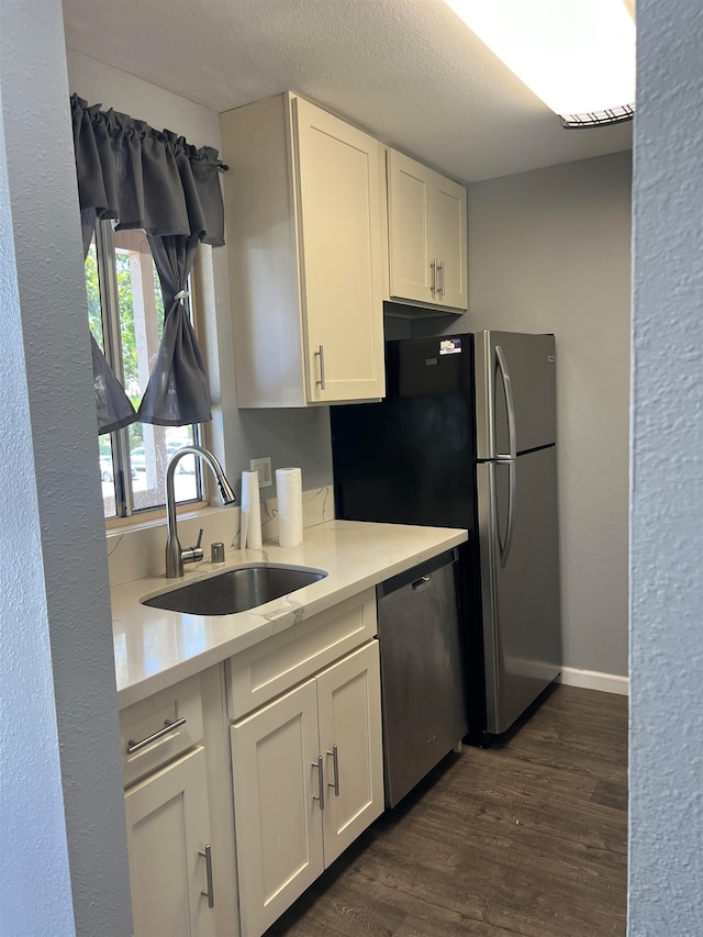 kitchen featuring stainless steel dishwasher, sink, white cabinets, and dark hardwood / wood-style floors