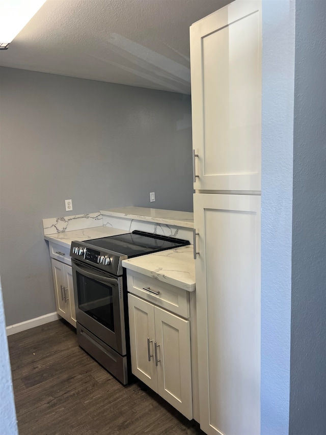 kitchen featuring white cabinetry, electric range, dark hardwood / wood-style floors, light stone countertops, and a textured ceiling