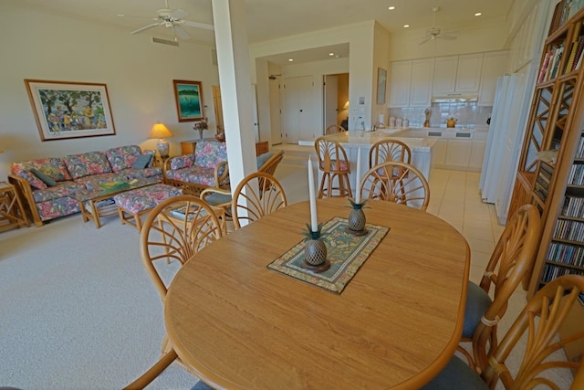 dining area with ceiling fan and light colored carpet