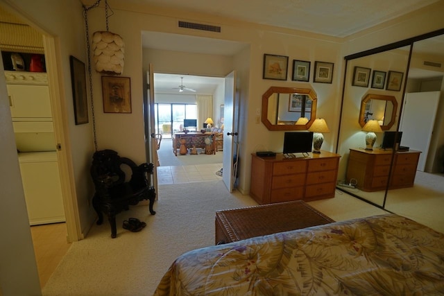 bedroom with stacked washing maching and dryer, a closet, and light tile floors