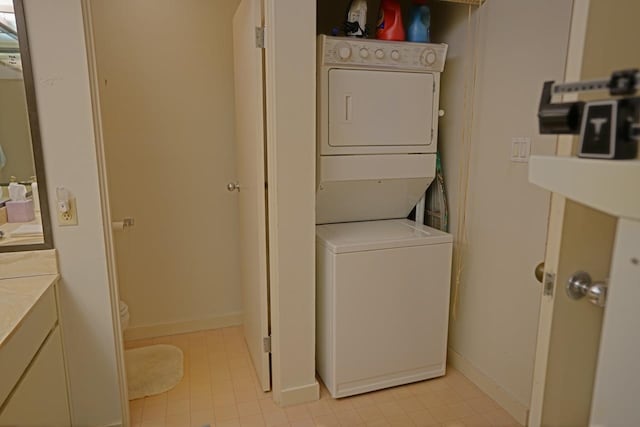 laundry room featuring light tile floors and stacked washer and dryer