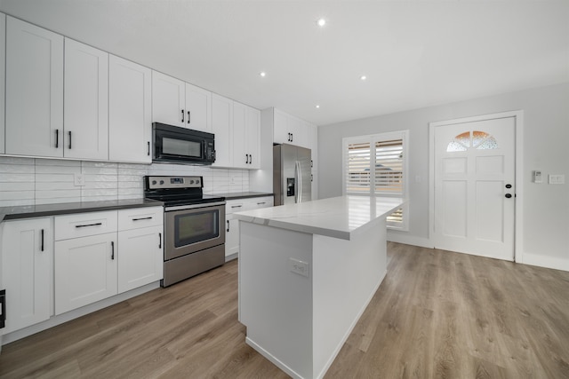 kitchen featuring white cabinetry, a center island, stainless steel appliances, and light hardwood / wood-style floors