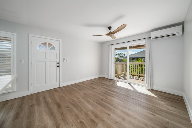 foyer entrance featuring hardwood / wood-style floors, a wall mounted AC, and ceiling fan