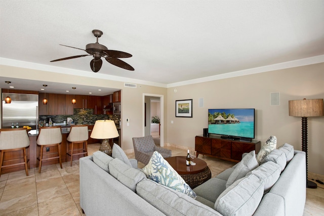 living room with ornamental molding, light tile patterned flooring, and ceiling fan