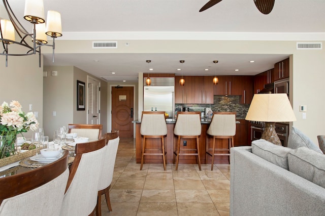 dining area with light tile patterned flooring and ceiling fan with notable chandelier