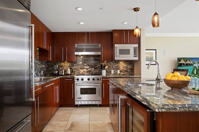 kitchen with high quality appliances, ventilation hood, sink, decorative light fixtures, and beverage cooler