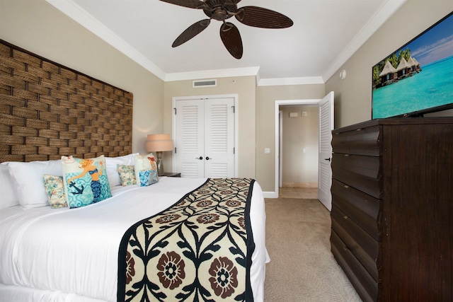 bedroom featuring a closet, ceiling fan, crown molding, and light colored carpet