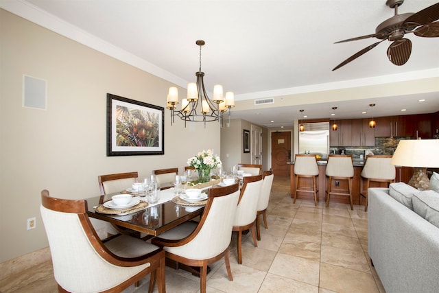 dining space with crown molding, ceiling fan with notable chandelier, and light tile patterned floors