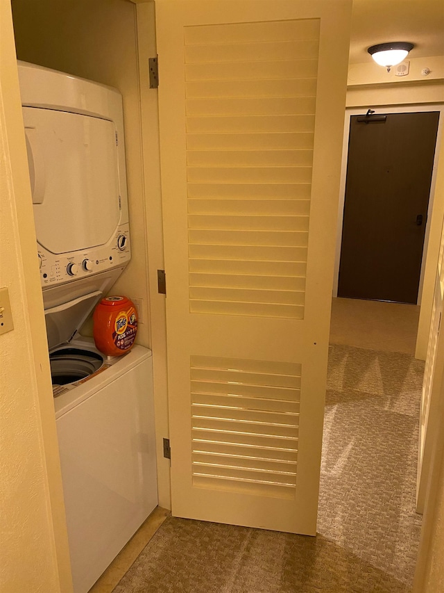 laundry area with stacked washer / dryer and carpet