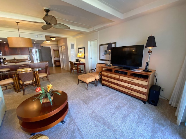 living room with carpet flooring, beam ceiling, and ceiling fan