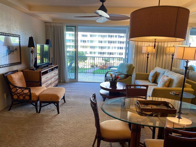 carpeted living room with ceiling fan