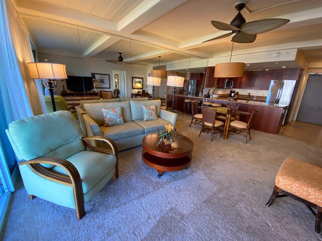 living room featuring ceiling fan, light colored carpet, beam ceiling, and coffered ceiling