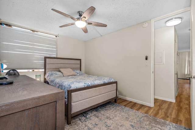 bedroom featuring a textured ceiling, light hardwood / wood-style flooring, and ceiling fan