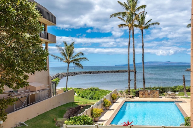 view of swimming pool with a water view and a patio