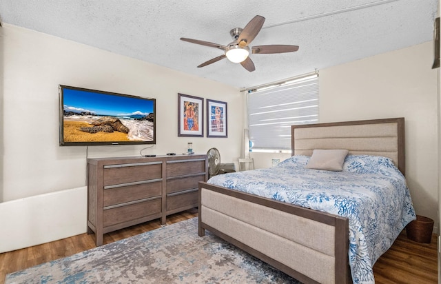 bedroom featuring wood-type flooring, a textured ceiling, and ceiling fan