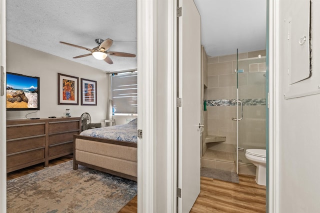 bedroom with light hardwood / wood-style flooring, ceiling fan, a textured ceiling, connected bathroom, and a closet