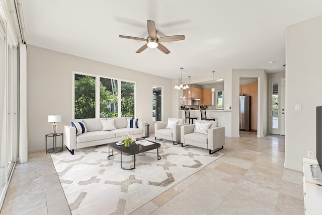 living room featuring ceiling fan with notable chandelier