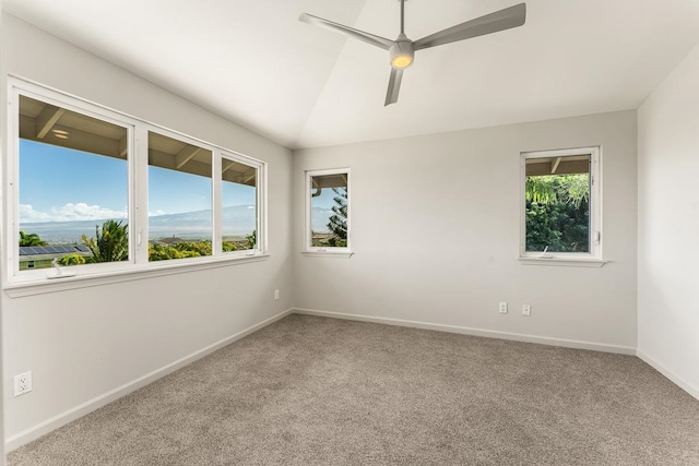 spare room featuring vaulted ceiling, light carpet, and ceiling fan