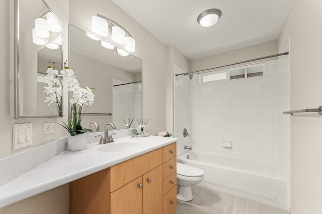 full bathroom featuring toilet, tiled shower / bath, and vanity