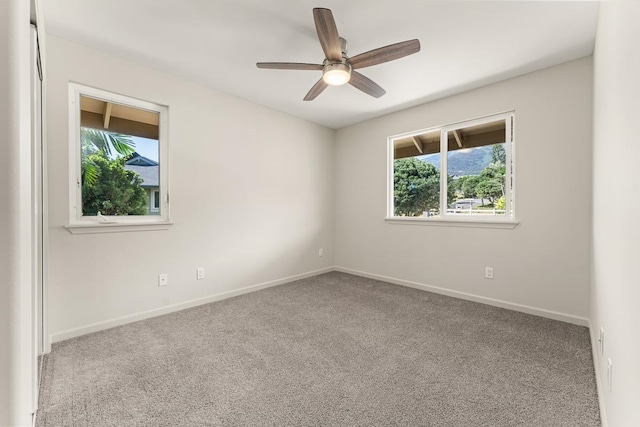 unfurnished room featuring ceiling fan, light colored carpet, and plenty of natural light