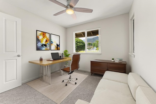 carpeted office space featuring ceiling fan