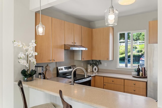 kitchen featuring light brown cabinetry, stainless steel electric range, and pendant lighting