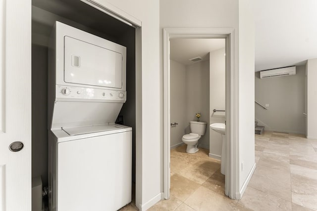 washroom with stacked washer and dryer and a wall mounted air conditioner