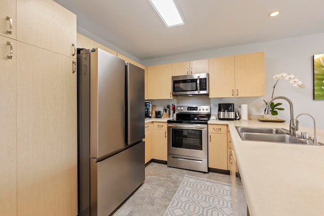 kitchen featuring light brown cabinets, stainless steel appliances, and sink