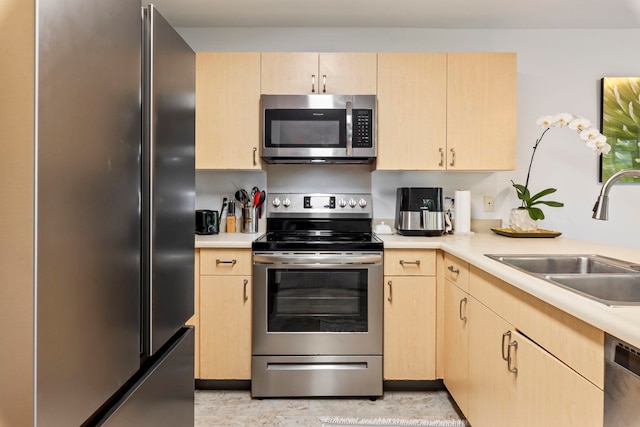 kitchen featuring light brown cabinetry, appliances with stainless steel finishes, and sink