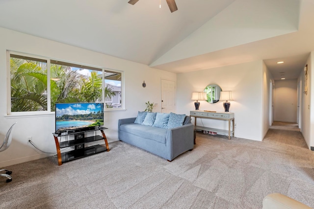 carpeted living room with ceiling fan and vaulted ceiling