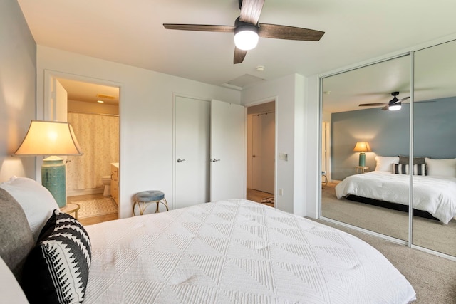 carpeted bedroom featuring ensuite bathroom, ceiling fan, and a closet