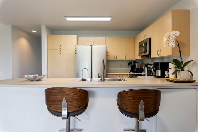 kitchen featuring light brown cabinets, white refrigerator, black / electric stove, and a breakfast bar area