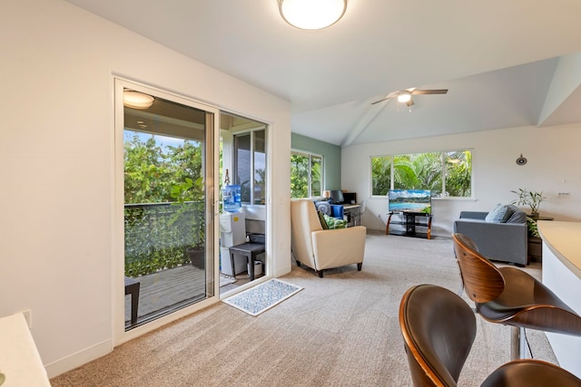 carpeted living room with ceiling fan and vaulted ceiling