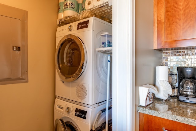 laundry room featuring stacked washing maching and dryer and electric panel