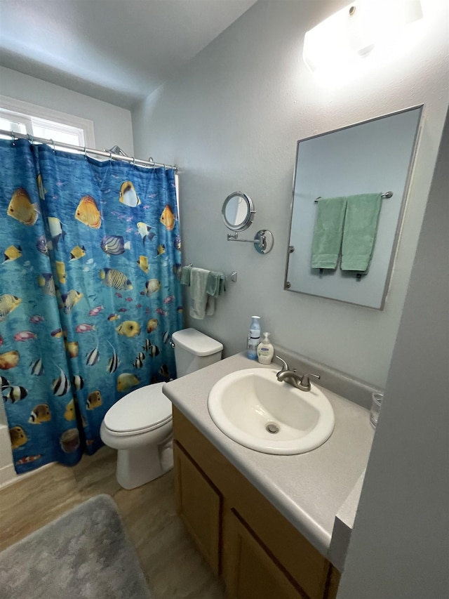 full bath with a shower with curtain, vanity, toilet, and wood finished floors