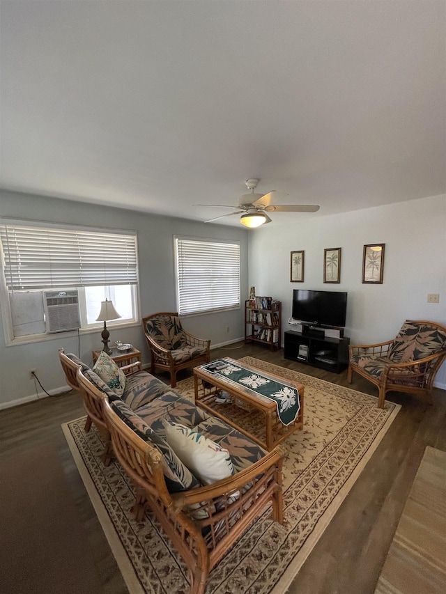 living area with a ceiling fan, cooling unit, baseboards, and wood finished floors