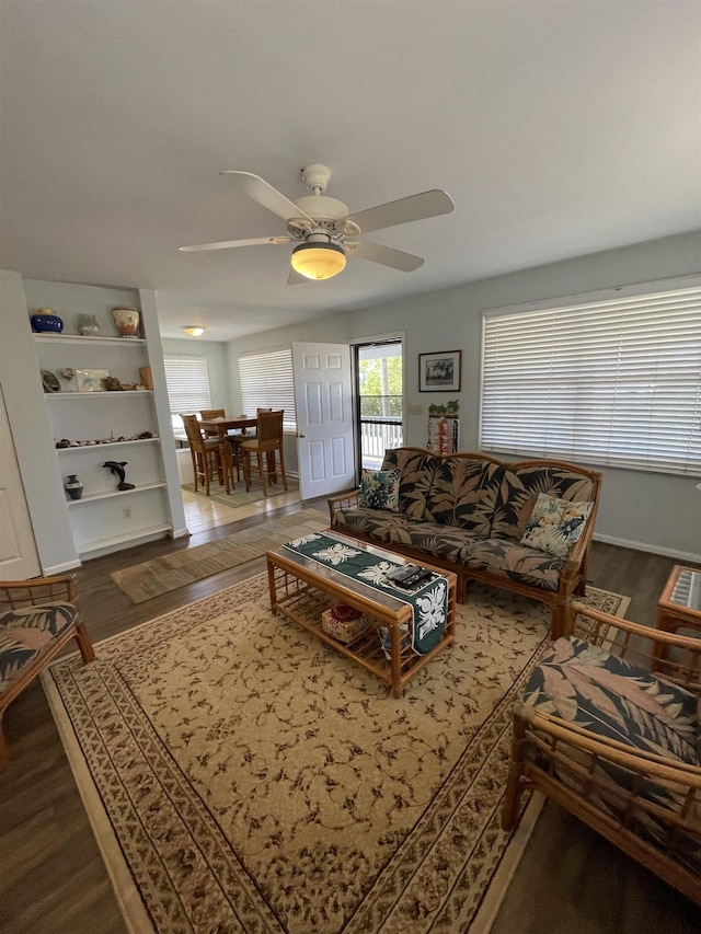 living area featuring dark wood-type flooring and a ceiling fan